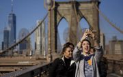 Verandert ons sociale mediagedrag door het Instagramexperiment? Foto: een groepje jongeren neemt een selfie op de Brooklyn Bridge in New York. Deze stad werd in 2017 het vaakst gedeeld op Instagram. beeld AFP, Drew Angerer