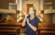 Elsaline Veldhuizen uit Den Haag werkt als tolk Nederlandse gebarentaal. Op de foto laat ze het gebaar zien voor het woord ”gunst.” beeld RD, 
Henk Visscher