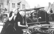 Twee Zeeuwse vrouwen rijden mee op een jeep van de geallieerden tijdens de bevrijding van Nederland.  beeld ANP