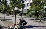 Een vrouw legt donderdag bloemen voor de woning van de vermoorde advocaat Derk Wiersum. In Italië werden in 70 jaar tijd 36 advocaten vermoord wegens hun beroep.  beeld ANP, Robin Utrecht