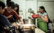 Maria Orellana kookt kippenstoof in de gaarkeuken van El Pobre de Asis, een stichting die hulp biedt aan armen en daklozen in Bue­nos Aires. beeld Julian Andres Galan