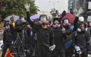 Demonstranten, uitgerust met gasmaskers en helmen, maakten zich donderdag in Hongkong gereed voor een confrontatie met de oproerpolitie. beeld EPA, Miguel Candela