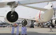 In de schaduw van een vliegtuig volgen bezoekers het programma van de Dubai Air Show. beeld Riekelt Pasterkamp