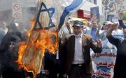 Volgens de Iraanse ”revolutieleider” Khamenei „impliceert de oproep tot liquidatie van de staat Israël niet het uit de weg ruimen van het Joodse volk.” Foto: Iraniërs verbranden een Israëlische vlag tijdens een parade in Teheran tegen het Israëlische geza