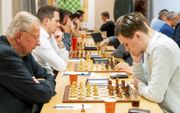 Hans Klein (74) en Joris Klein (18) spelen een potje schaak tegen elkaar. beeld Cees van der Wal