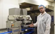 Productieleider Jan de Muynck bij de machine die glutenvrij deeg verwerkt. beeld Van Scheyen Fotografie