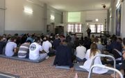 Vluchtelingen en internationale vrijwilligers komen elke zondag in gebouw Oasis op Lesbos bijeen voor een internationale kerkdienst. beeld RD