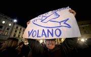 Een man houdt een bord met een sardientje omhoog tijdens een protest in Florence, eind november. Zaterdag houdt de protestbeweging van de ‘sardientjes’ een grote betoging in Rome. beeld AFP, Filippo Monteforte
