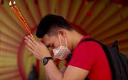 Een man draagt een beschermend masker terwijl hij bidt in een Chinese tempel in Bangkok, de hoofdstad van Thailand. Thaise gezondheidsfunctionarissen zijn extra alert nadat duidelijk werd dat er in Thailand veertien mensen besmet zijn met het coronavirus.