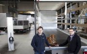 De broers Jan (links) en Henk (rechts) samen met bedrijfshond Pelle in de werkplaats in Barendrecht. „Een huiskamersfeer is belangrijk.” beeld Anton Dommerholt