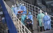 Medisch personeel brengt dinsdag patiënten over naar het nieuwe tijdelijke Huoshenshan-veldhospitaal in het Chinese Wuhan, Het aantal officieel vastgestelde besmettingen is tot boven de 20.000 gestegen. beeld EPA