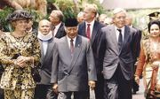 Een foto verhult soms veel. President Soeharto bereidde koningin Beatrix en prins Claus in 1995 geen warme ontvangst. Achter hen minister Van Mierlo van Buitenlandse Zaken en kroonprins Willem-Alexander. Die laatste gaat nu zelf op staatsbezoek in de vroe