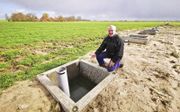 Akkerbouwer Alex van Hootegem laat de putten zien, waarin overtollig regenwater wordt opgevangen en daarna in de ondergrond gepompt als opslag voor droge tijden. beeld Van Scheyen Fotografie