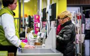 Klanten doen dinsdagochtend hun boodschappen in een filiaal van PLUS in het Brabantse Engelen. Meer supermarkten kiezen er in navolging van Albert Heijn en Jumbo voor om maatregelen te treffen om besmetting van personeel en klanten met het coronavirus te 
