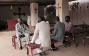 Voorganger Yousef Zamgila (l.) in zijn kleine geïmproviseerde kerk in Omdurman, Sudan. Hij hoopt op betere tijden na de val van oud-president Bashir. beeld AFP, Jean Marc Mojon