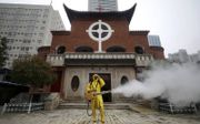 Een kerk in Wuhan wordt gedesïnfecteerd. beeld EPA