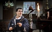 Een man steekt kaarsen aan in de Portugese Synagoge in Amsterdam. Onder andere de gezamenlijke gebeden en het lezen uit de Thorarol kunnen niet plaatsvinden. ​beeld ANP, Ilvy Njiokiktjien