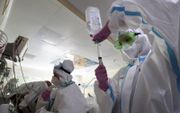 Artsen bereiden een injectievloeistof voor een coronapatiënt op een ic in Moskou. beeld EPA, Sergei Chirikov