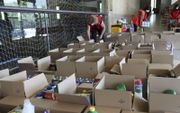 Medewerkers van het Rode Kruis maken voedselpakketten klaar. beeld Lex Rietman
