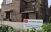 In de tuin van de kerk van de gereformeerde gemeente van Dordrecht kwam een bord met daarop een link naar de livestream op YouTube. beeld G. T. S. de Korte