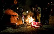 Demonstranten verbranden een Amerikaanse vlag tijdens een protest tegen racisme en politiegeweld in het centrum van de Amerikaanse stad Portland in de staat Oregon. beeld EPA, Etienne Laurent