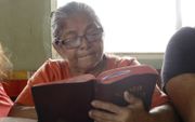 Een vrouw uit Ecuador leest in haar Bijbel. beeld ZGG