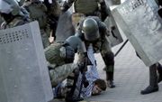 De Wit-Russische ordepolitie arresteert een demonstrant tijdens protesten in Mink, donderdag. beeld AFP, Tut.by