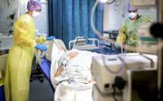 Verplegend personeel verleent zorg aan een coronapatiënt op de intensive care. beeld ANP, Remko de Waal