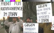 Iraniërs in Duitsland demonstreren tegen de Iraanse overheid tijdens een proces na de moord op de vier leiders van de belangrijkste Koerdische beweging in Iran, op 17 september 1992 in het Griekse restaurant Mykonos in Berlijn. beeld AFP, Peer Grimm