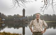 Henk Ruseler, boswachter bij het Nationale Park de Hoge Veluwe. Op de achtergrond het Jachthuis Sint Hubertus. beeld RD, Henk Visscher​