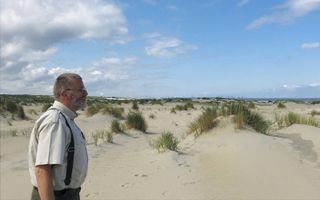 Boswachter Fred Spreen van Het Zuid-Hollands Landschap kijkt uit over de Zandmotor. Op de achergrond de Tweede Maasvlakte  beeld RD