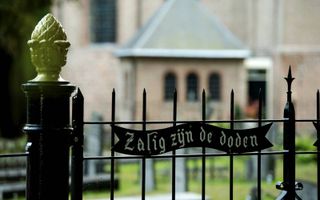 Op het hek bij de ingang van de begraafplaats prijkt een tekst uit Openbaring 14. beeld ANP, Robin van Lonkhuijsen