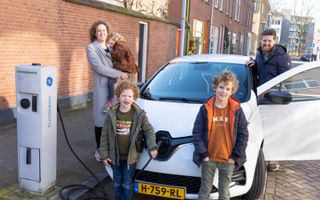 Jan en Annemarie Karens met hun drie kinderen bij een elektrische deelauto in de Utrechtse wijk Lombok. beeld RD, Anton Dommerholt