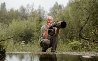 Natuurfotograaf Han Bouwmeester bij de vijver van een van zijn fotohutten. beeld Speechless Photography