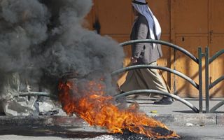 Brandende autobanden als gevolg van rellen op de Westoever. beeld AFP, Hazem Bader