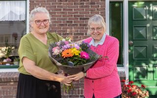 Petra de Gier-Stigter (l.) geeft haar zus Jannie Stigter een bos bloemen. „Jannie zit nooit stil en helpt waar ze kan helpen.” beeld Erik Kottier