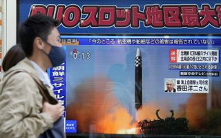 Voetgangers in de Japanse hoofdstad Tokio lopen langs een televisie met nieuws over het afvuren van een ballistische raket door Noord-Korea. beeld EPA, KIMIMASA MAYAMA