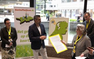 Yvonne Koopman overhandigt de petitie van GezinsPlatform.nl aan commissievoorzitter Kuzu (Denk). beeld Dirk Hol