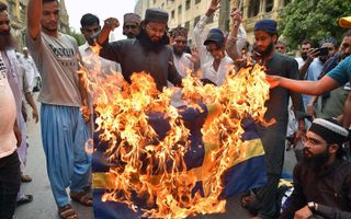 Moslims in de Pakistaanse stad Karachi verbranden vrijdag een Zweedse vlag. beeld EPA, Shahzaib Akber