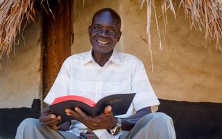 Een inwoner van Zuid-Soedan leest in zijn Bijbel. beeld Wyliffe