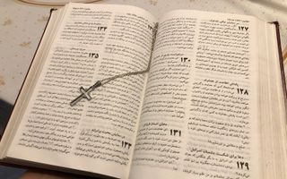 Een Bijbel in Farsi, met het kettinkje van een Iraanse vrouw die christen is geworden.  beeld RD