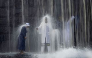 Pelgrims tijdens een eeuwenoud ritueel onder een waterval in Johannesburg. Beeld EPA, Kim Ludbrook