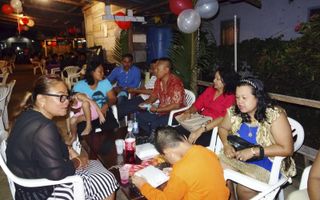 Het meest eenvoudige Surinaamse verjaardagsfeest is het „zitje” bij mensen thuis op het erf. Dat heeft nog enig raakvlak met de Hollandse koffie-met-gebakversie.  beeld Armand Snijders