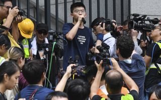 De prodemocratische activist Joshua Wong (22) sprak eind juni honderden betogers toe voor het politiehoofdkwartier in Hongkong. beeld AFP, Anthony Wallace