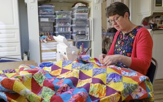 Laura Strating-Janssens is in haar atelier bezig met een quilt. Naast het zelf maken, leert zij ook aan cursisten hoe ze deze doorgestikte dekens kunnen vervaardigen.  beeld Sjaak Verboom