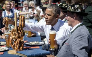 Hm, wat is dat toch allemaal? President Obama kreeg tijdens de G7-top in 2015 in Beieren een totaal ander ontbijt dan thuis. Een Breze, een worst om naar binnen te slobberen en natuurlijk een halve liter witbier.  beeld EPA, Steffen Kugler