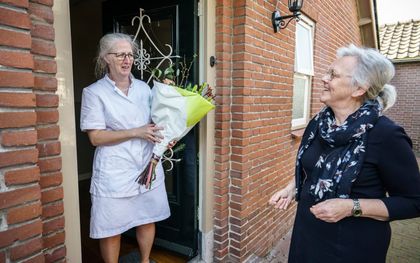 Corrie Oomen (r.) overhandigt predikantsvrouw Gerda van Meggelen (l.) een bloemetje. Oomen: „Ze ziet de nood bij mensen. Ze helpt haar naaste belangeloos. Ik heb veel respect voor haar.” beeld Maikel Samuels