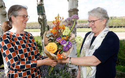 Ria van Meerten-Van Garderen uit Opheusden (l.) geeft haar schoonzus Dirkje van Meerten-Verwoert een bloemetje. „Ze zet zich al zestien jaar met hart en ziel in voor Woord en Daad.” beeld VidiPhoto