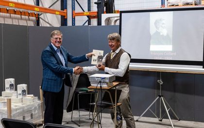 Redacteur Joop Hardeman (links) van uitgeverij Gebr. Koster overhandigt het eerste exemplaar van ”Bijbel, Bantoes en Boeren” aan Gerrit van Dijk. beeld André Dorst