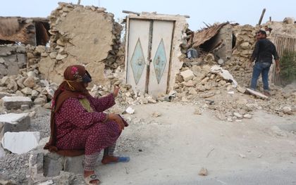 Een vrouw zit buiten het puin van haar huis in de nasleep van een krachtige aardbeving, in het dorp Sayeh Khosh, provincie Hormozgan, Zuid-Iran. beeld EPA, Abdol Hossein Rezvani